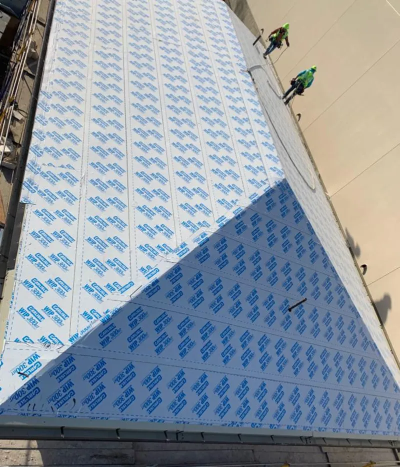 Professional roofers installing underlayment on a metal roof in Shelley